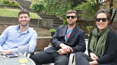 Group of young adults sitting round smiling.